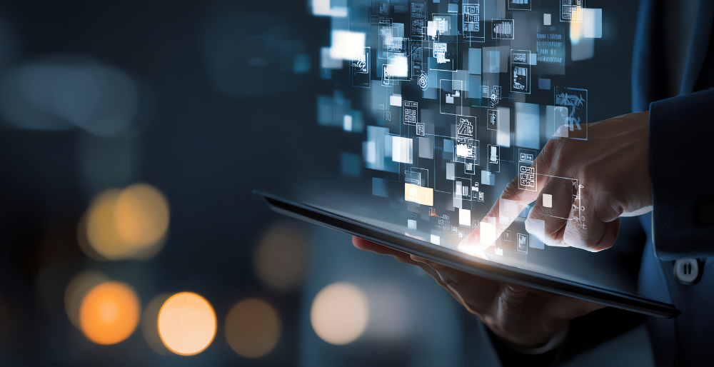 Businessperson using a tablet with floating holographic data projections and icons in a dark tech background.